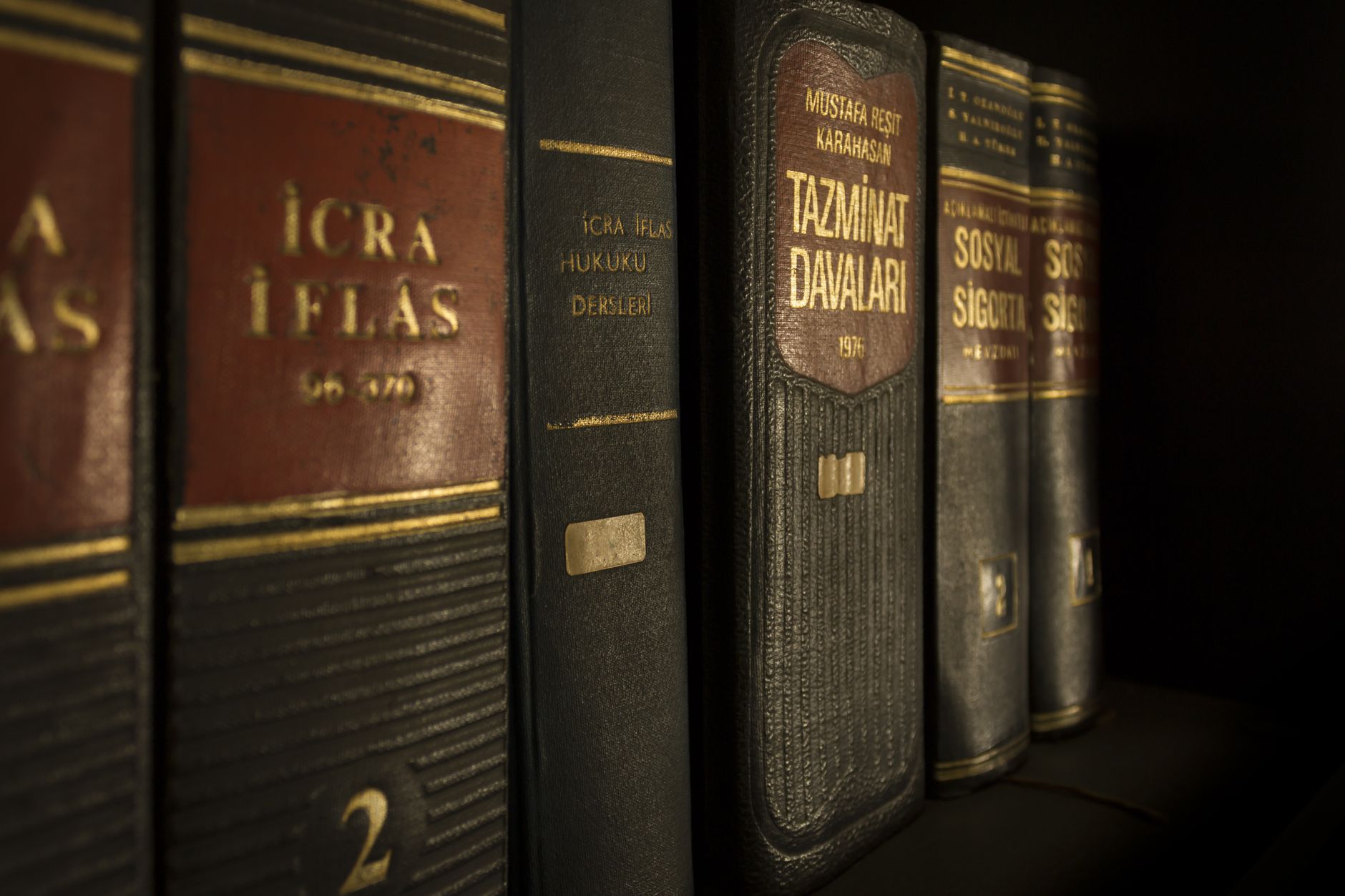 Students studying with law books and laptops in a quiet university library setting.