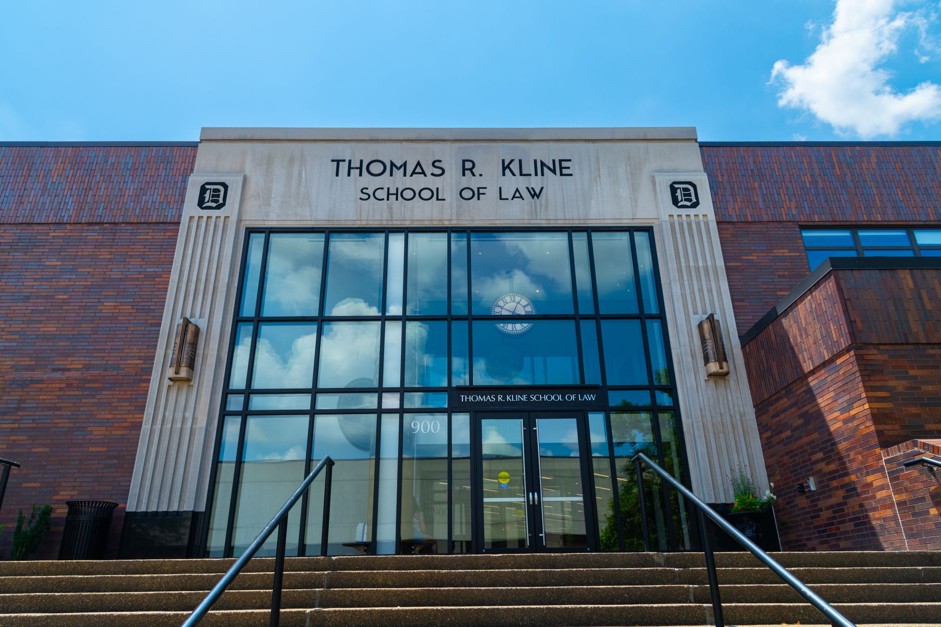Exterior view of a university law school building with columns and steps.